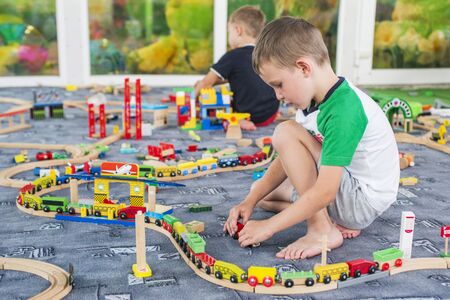 Child play with wooden train, build toy railroad at home or kindergarten. Toddler kid play with wooden trainの写真素材