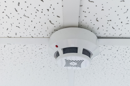 Modern smoke sensor hanging on ceiling. Temperature gage circular wall.The wall of the smoke sensor on the ceiling of the circularの写真素材