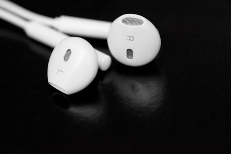 White earphones on black background. Copy space. Music is my life concept. Earbuds or earphones on black backgroundの写真素材