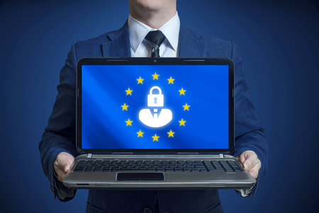 General Data Protection Regulation. A man holds in his hands a laptop with a blue background and a GDPR sign on the screen. GDPR conceptの写真素材