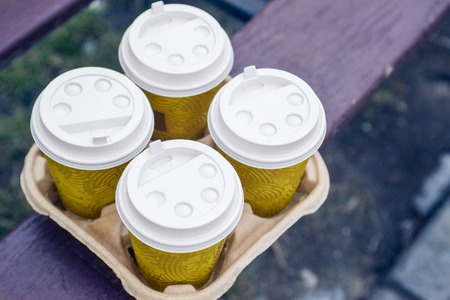 Four take-out coffee in holder. Take coffee to work for the entire office. Coffee time conceptの写真素材