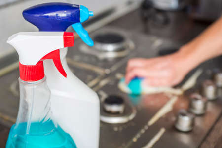 Detergents for washing the stove. Cleaning a gas stove with kitchen utensils, household concepts, or hygiene and cleaning.の写真素材