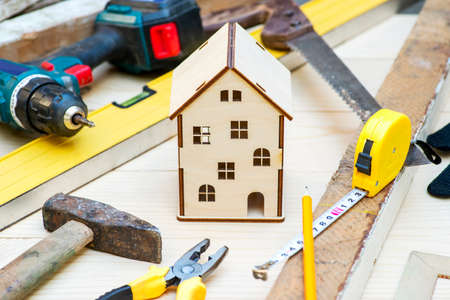 Wooden house toy surrounded by tools. Concept home repair. Home improvement. Renovate home.の写真素材