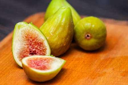 Ripe fresh figs on a cutting kitchen board on a rustic wooden table. Ripe tasty figs.の写真素材