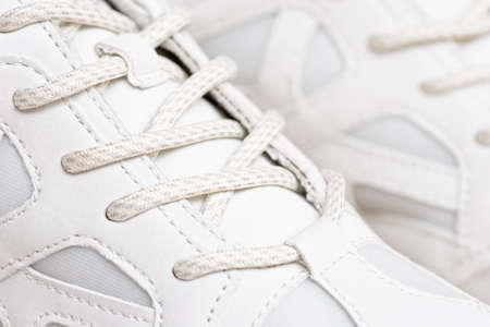 Pair of white sneakers with shoelaces closeup. New white sneakers and white shoelaces in closeup.の写真素材