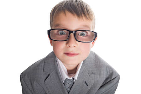 Portrait of a funny child boy wearing glasses against a white background. Smart child in suit and glasses looking at camera. Back to school and education concept.の写真素材