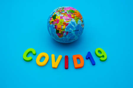 Globe and text COVID 19 on a blue background. Coronavirus / Corona virus concept. The spread of corona virus in the World.の写真素材