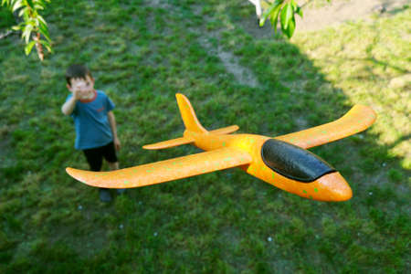 Little boy launches a toy plane into the air. Child launches a toy plane.の写真素材