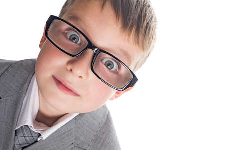 Portrait of a funny child boy wearing glasses against a white background. Smart child in suit and glasses looking at camera. Back to school and education concept.の写真素材