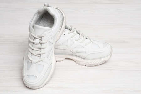 Sneakers on a white wooden background with copy space. Fashionable sneakers on a wooden background. Sport shoes.の写真素材