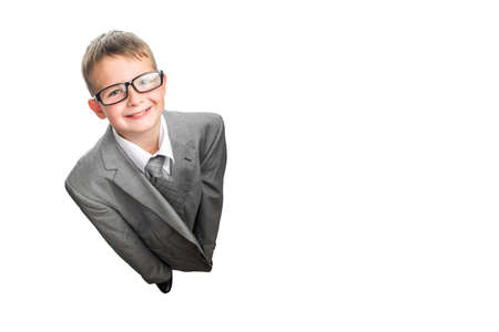 Small child dressed in a business suit and glasses as a businessman, top view. Child in his fathers suit isolated on white background.の写真素材