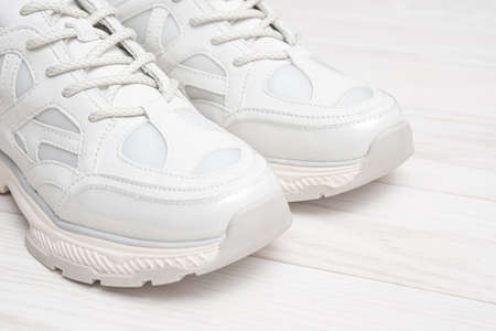 Sneakers on a white wooden background with copy space. Fashionable sneakers on a wooden background....