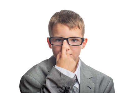 Child dressed as an adult businessman straightens glasses with his finger. Face of smart boy in glasses and adult suit isolated on white background.の写真素材