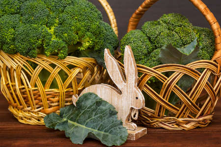 Fresh green broccoli cabbage in a wicker baskets on wooden table. Healthy or vegetarian food concept.の写真素材