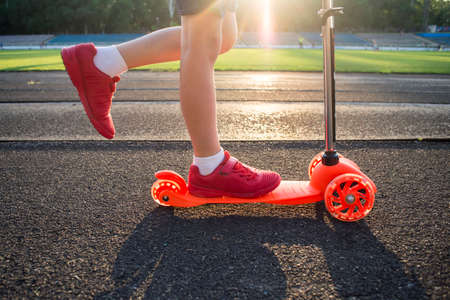 Little boy is riding scooter. Seasonal child activity sport. Healthy outdoor activity. Active leisure and outdoor sport for children.の写真素材