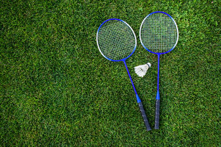 Rackets and a shuttlecock for badminton on the grass.Top view. Concept of summer hobby, outdoor...