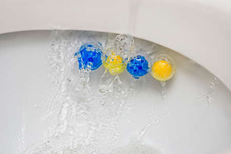 Clean toilet bowl with a cleaning and refreshing balls. Multi-colored balls of toilet bowl cleaner.の写真素材