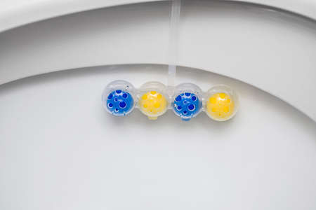 Clean toilet bowl with a cleaning and refreshing balls. Multi-colored balls of toilet bowl cleaner.の写真素材