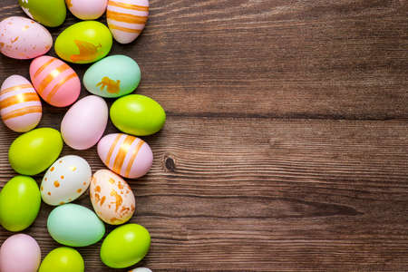 Colorful Easter eggs on wooden background, flat lay. Space for text.の写真素材