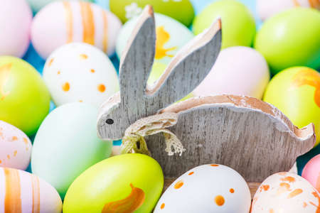 Colorful Easter eggs and wooden rabbit. Cute rabbit among Easter eggs.の写真素材