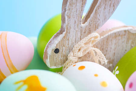 Colorful Easter eggs and wooden rabbit. Cute rabbit among Easter eggs.の写真素材