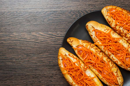 Tasty hot dogs on a black plate on a wooden background. Top view, copy space.の写真素材