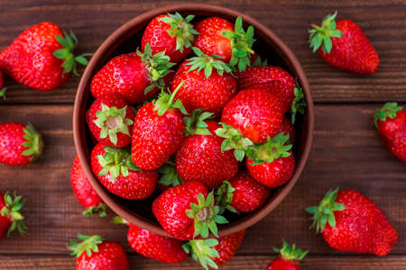 Fresh strawberries in a bowl on wooden table. Strawberry in a Bowl. Top view.の写真素材