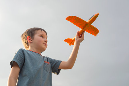 Little boy launches a toy plane into the air. Child launches a toy plane.の写真素材