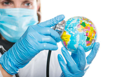 Doctor using a stethoscope to listen to the planet Earth globe and set diagnosis, global medical health check concept. The concept of global health care.の写真素材