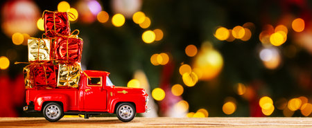 Banner photo of red small retro toy truck with christmas giftsの写真素材