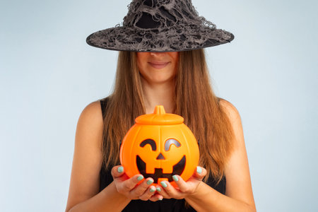 Happy young woman in halloween witch costume with pumpkin basketの写真素材