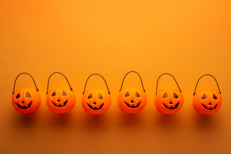 Halloween decorations with pumpkin baskets on orange backgroundの写真素材