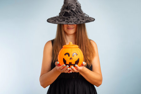 Happy young woman in halloween witch costume with pumpkin basketの写真素材