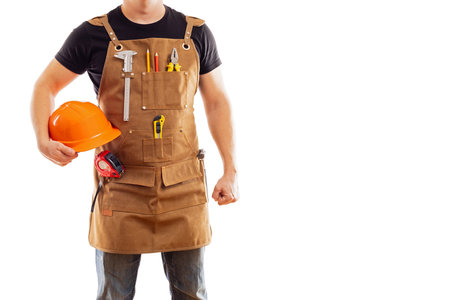 Contractor worker or carpenter in apron with tools and helmetの写真素材