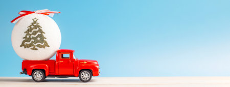 Christmas red retro car with a Christmas ball on a blue backgroundの写真素材