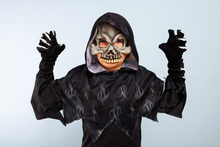 Portrait of angry little boy in halloween costume with frightening gestureの写真素材