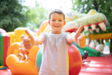 Happy boy having a lots of fun on a colorful inflate castleの写真素材