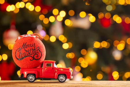 Red retro toy truck with Christmas ball on wooden tableの写真素材