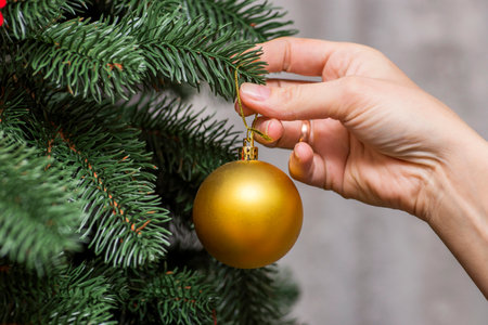 Close up image of womans hand decorating Christmas tree with bubblersの写真素材