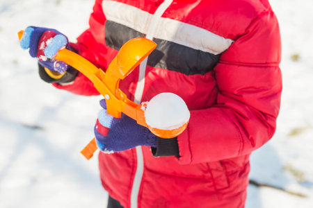 Device for sculpting snowballs in childrens hands on background of snowの写真素材