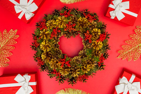Xmas wreath and gift boxes with white ribbon on red backgroundの写真素材