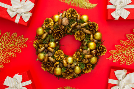 Xmas wreath and gift boxes with white ribbon on red backgroundの写真素材