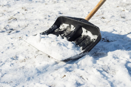Cleaning snow with a black shovel in the countryside after a heavy snowfallの写真素材