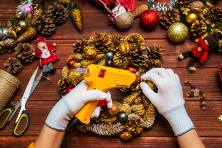 Creating a Christmas wreath with womens hands on a wooden backgroundの写真素材