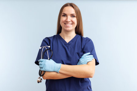 Female doctor in uniform with stethoscope on a blue backgroundの写真素材