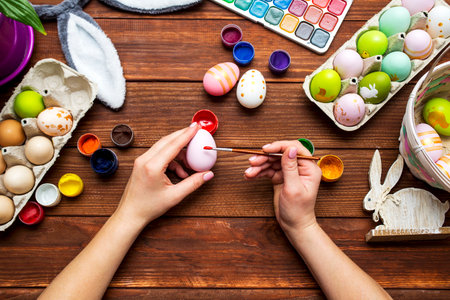 A woman with a tassel paints Easter eggs. Preparing decorations for Easterの写真素材