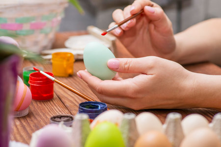 A woman with a tassel paints Easter eggs. Preparing decorations for Easterの写真素材