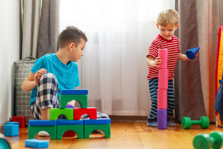 Cute little kids playing with colorful plastic toys or blocksの写真素材