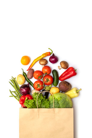 Fresh vegetables in eco friendly paper bag on white background, top viewの写真素材