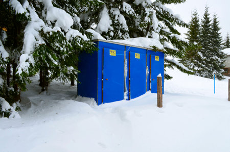 Snow-covered, blue, portable toilet on a winter dayの写真素材